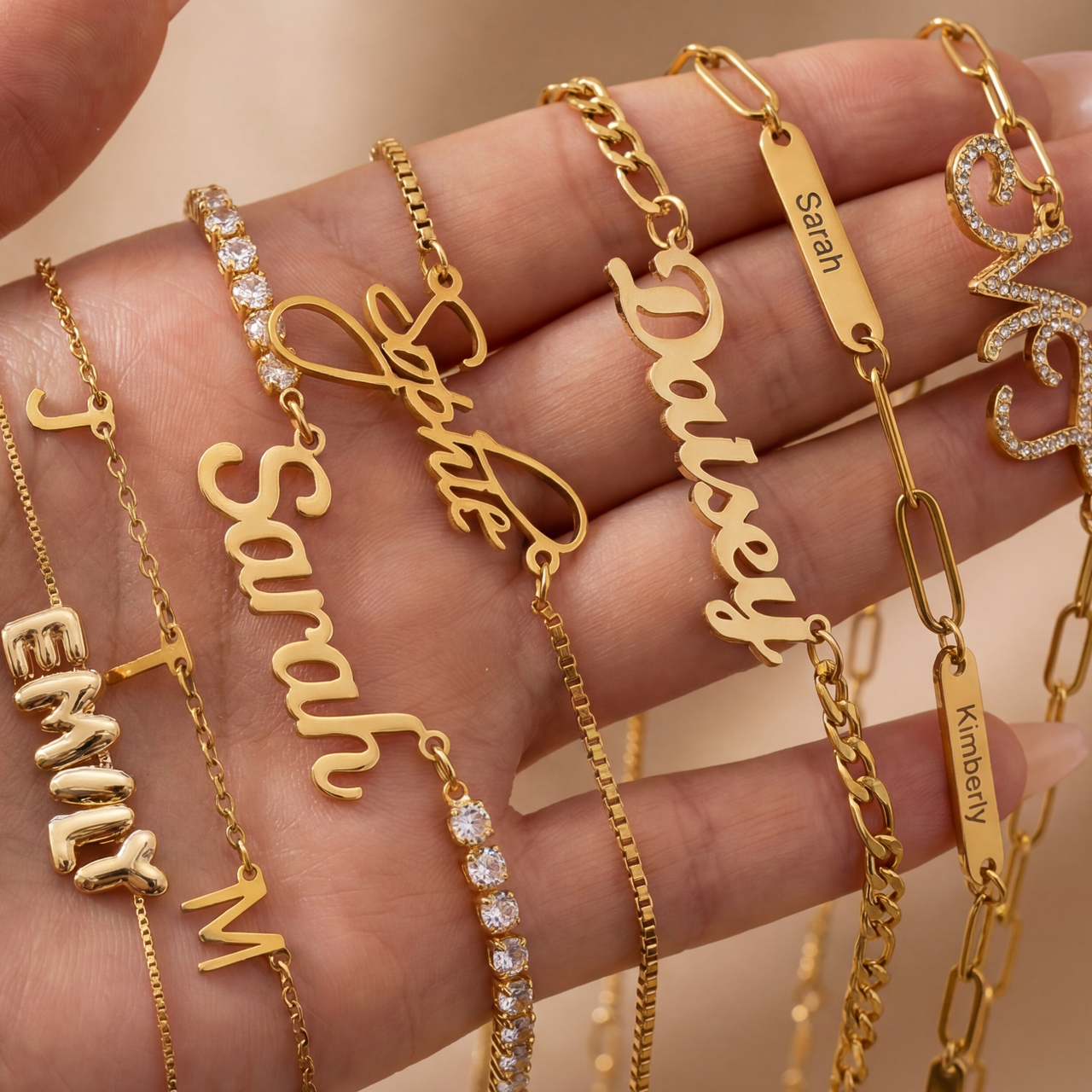 Personalise gold name bracelets on a hand with a beige background